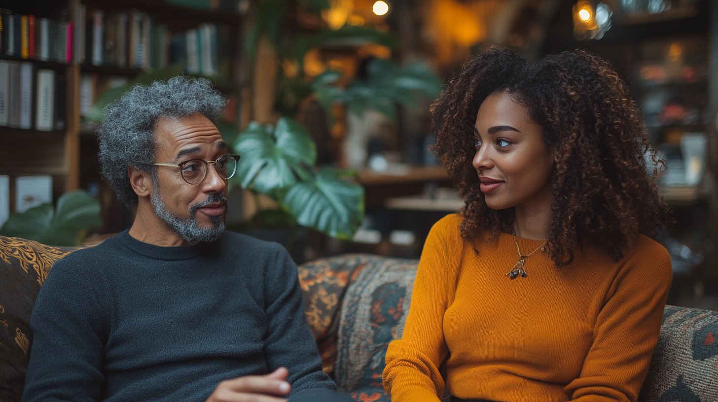 Zwei Menschen führen ein herzliches Gespräch auf einer Couch.